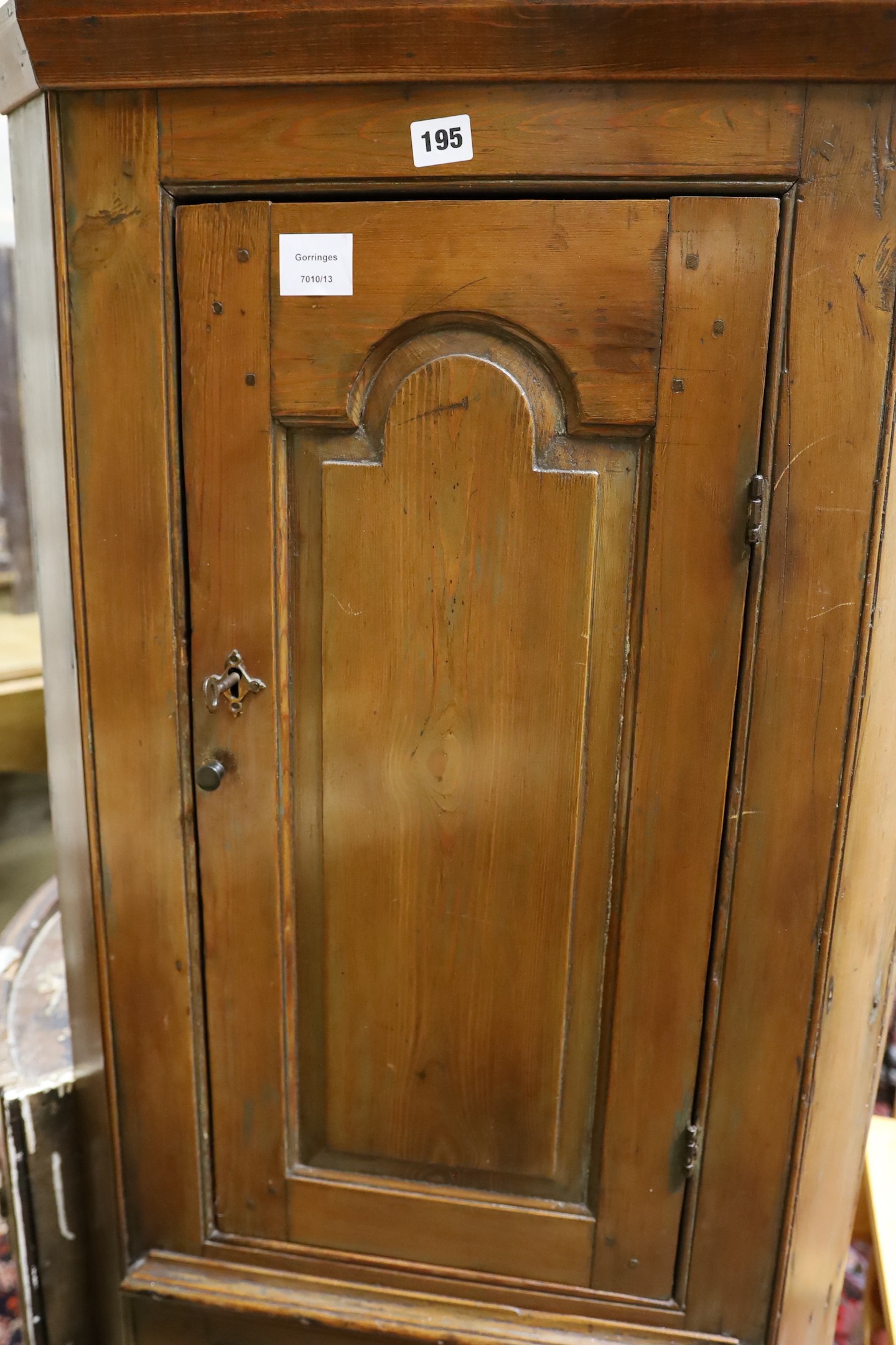 A small early 19th century pine two door standing corner cabinet, (lacking back leg) width 58cm, depth 30cm, height 150cm